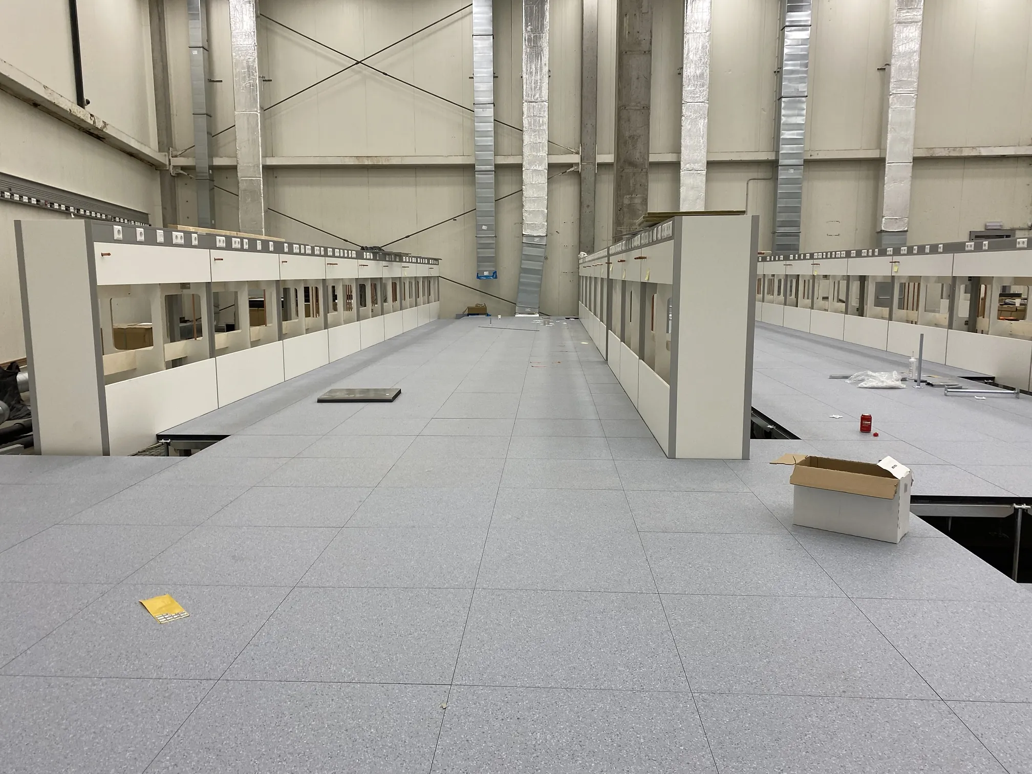 Computervloer in een laboratorium met labopstellingen op de vloer, tijdens de montage door Anomalie